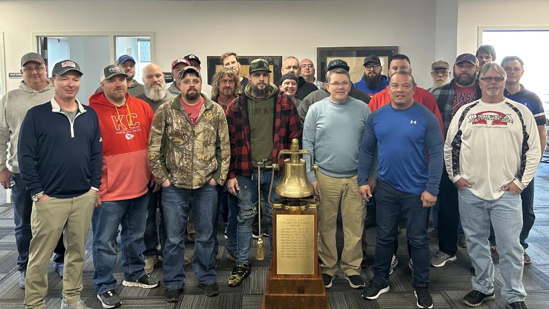 Heartland craft professionals stand with the Safety Bell. | LR