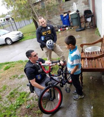 Sacramento police offcers discuss safety and build relationships through the bike giveaway program.