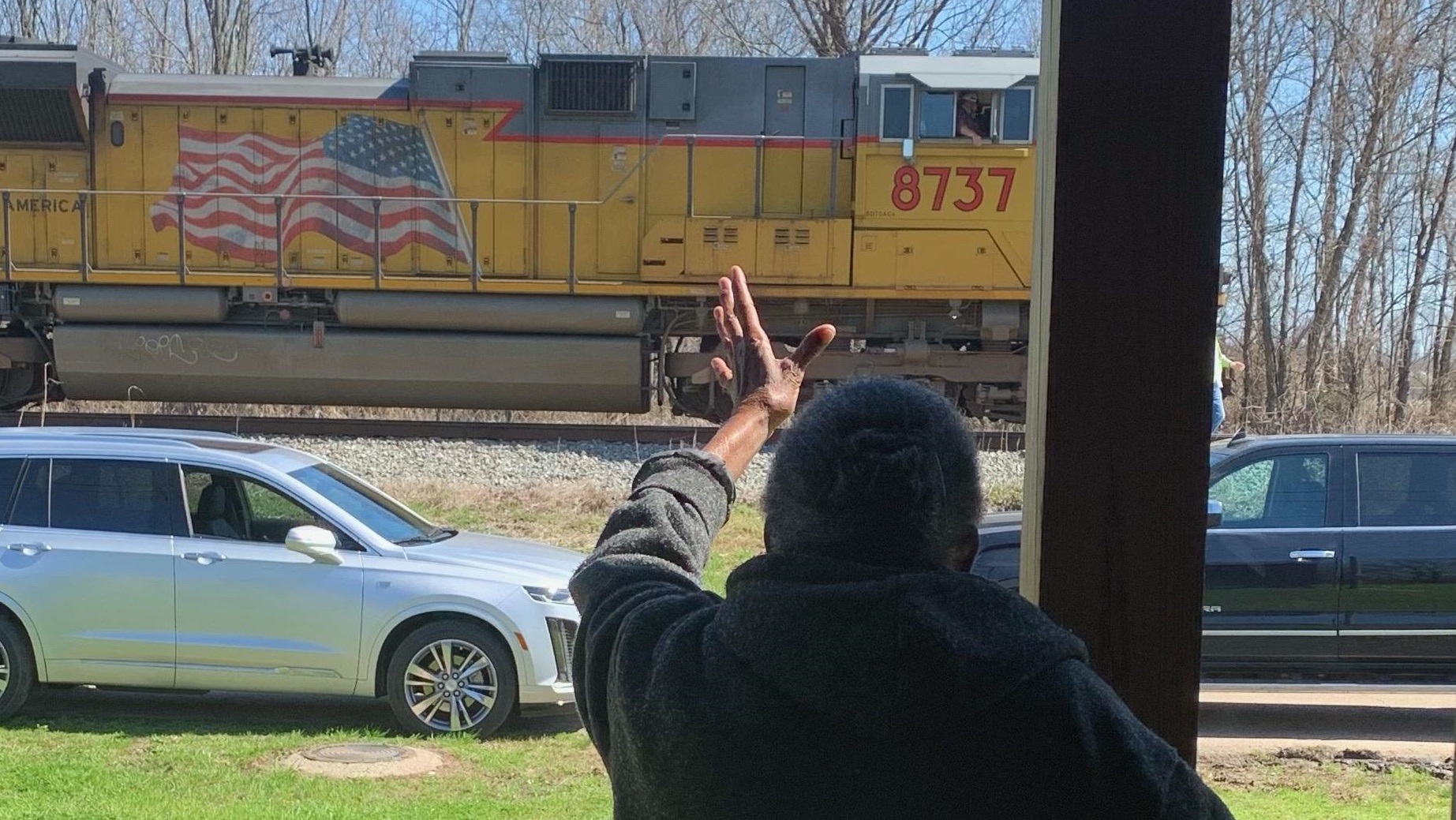 McGehee, Arkansas, woman waves at a passing train from her home.
