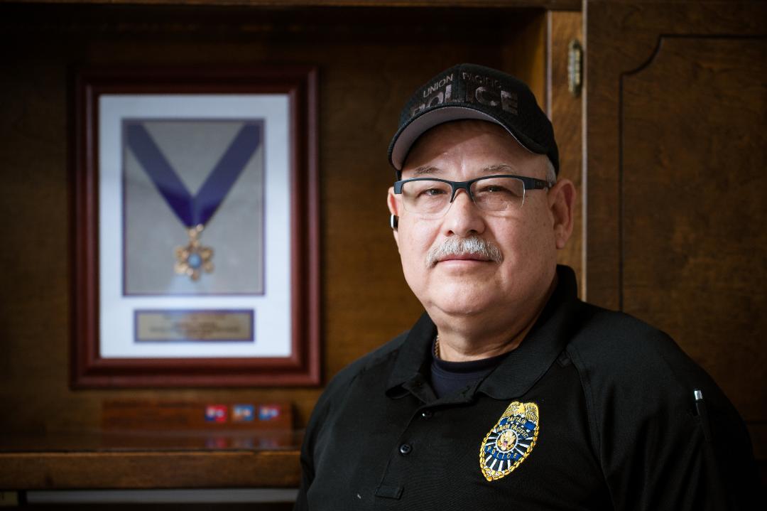 Oscar Garcia, Jr., stands in front of his purple heart medal.