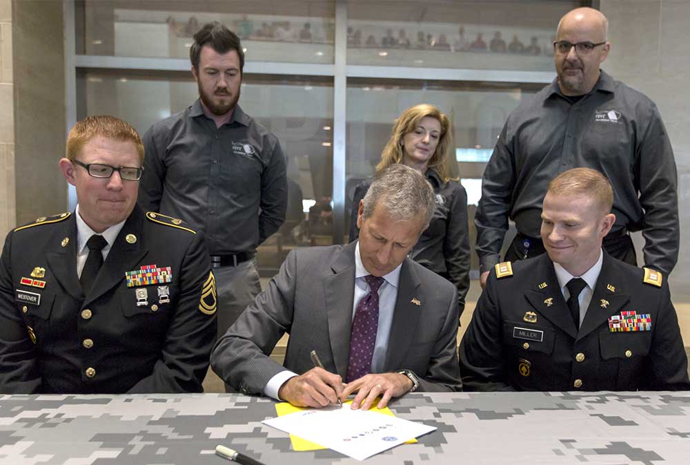 Building America Report 2016 - Lance Fritz signs the Employer Support of the Guard and Reserve documents.