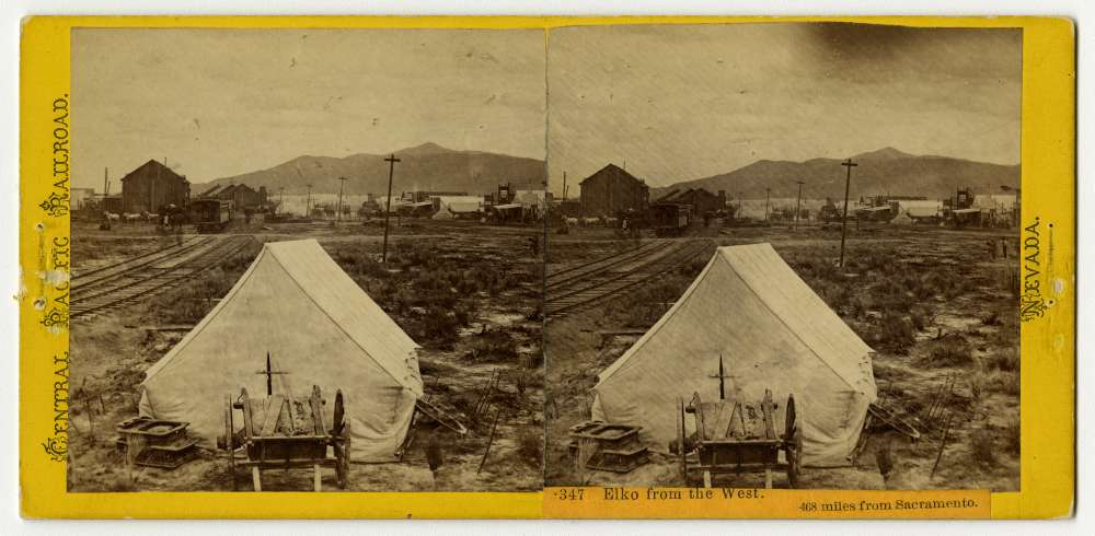 A stereo card of a cart resting next to a tent in the town of Elko, Nevada