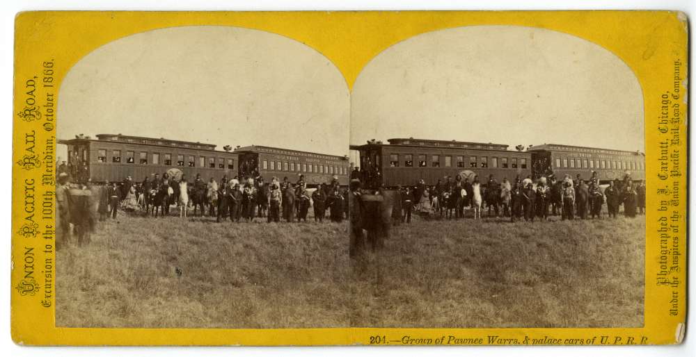 A stereocard showing a group of Pawnee warriors and palace cars of U.P.R.R.