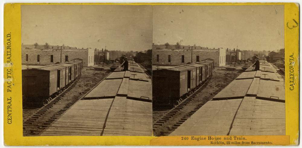 A stereo card showing a man standing between boxcars at the station in Rocklin