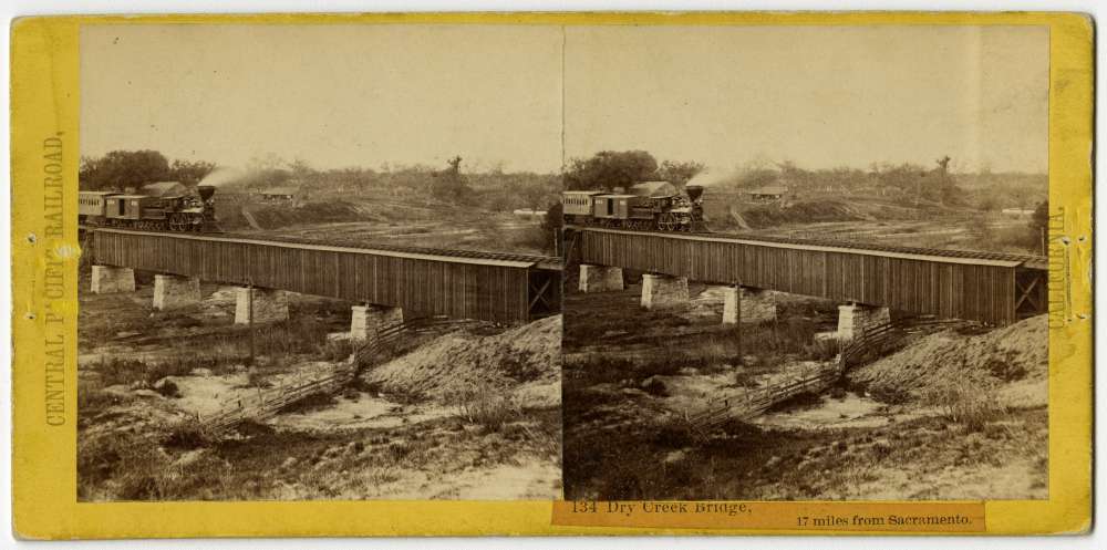 A stereo card showing a locomotive traveling over Dry Creek Bridge, south of Roseville, California