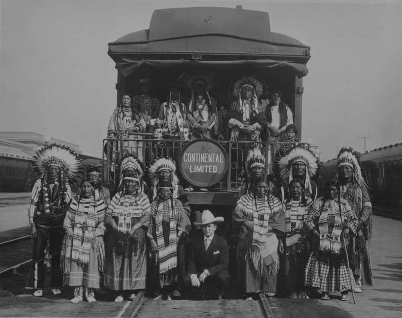 Arapahoe and Shoshone Native Americans stand on rear platform of Continental Limited with Tim McCoy
