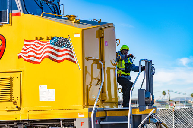 Union Pacific railroader stands next to locomotive.