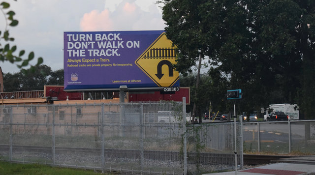 Billboard posted that reads: Turn back. Don't Walk On The Track.