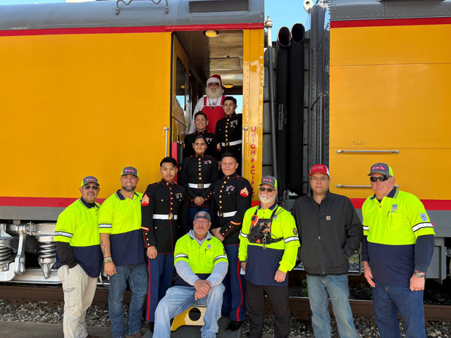 Union Pacific employees, U.S. Marines and Railroad Santa pose with the train helping carry toys for the annual Toys for Tots drive.