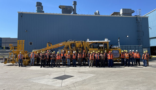A dedicated team of Union Pacific mechanics stands with the 100th rebuilt tamper machine at the Denver shop.
