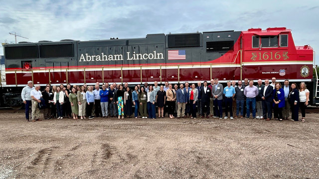 Union Pacific leaders and Industrial customers pose with the No. 1616 Lincoln Locomotive on a temporarily inactive track closed to rail traffic. Safety was prioritized during this special event.