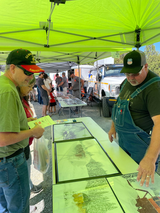 Don Loiler, right, a lead mechanic from Roseville, California, staffs a booth at Colfax Railroad Days.