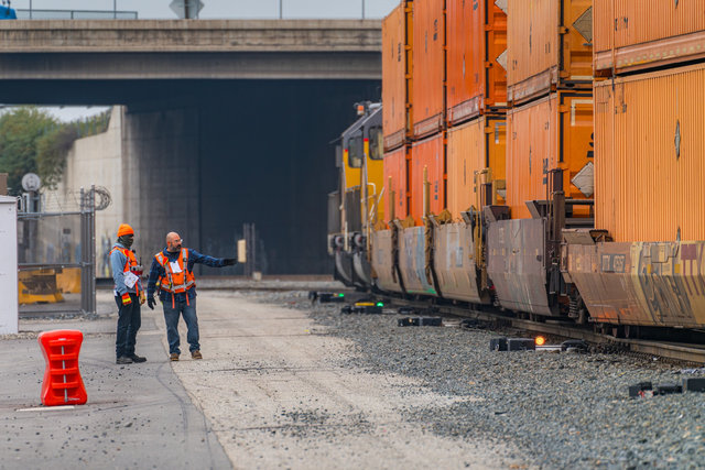 : A Union Pacific Transportation employee reviews safety protocols with a new hire at a California intermodal terminal, including how remote-control power switch technology helps safely and efficiently sort rail cars across the network.