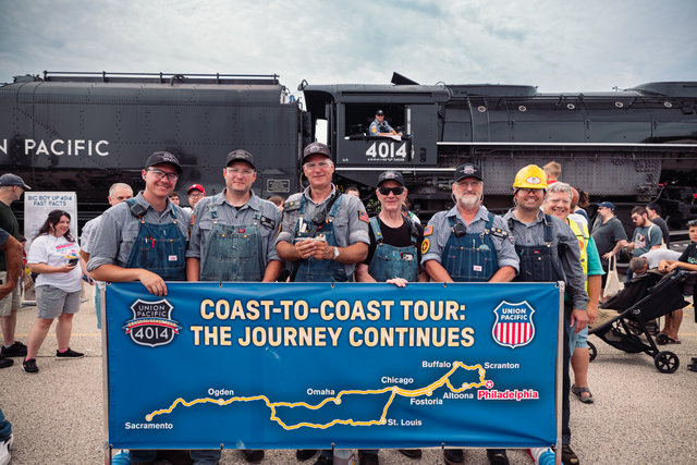 Union Pacific's steam crew poses in Philadelphia in front of a map of the 2026 Coast-to-Coast steam tour.