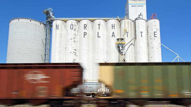 A train blurs by an grain elevator spelling the words 'North Platte" in North Platte, Nebraska.