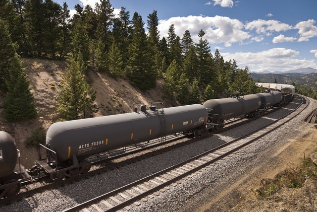 Tank cars and gondolas are visible on this manifest train rounding the bend near Denver, Colorado.