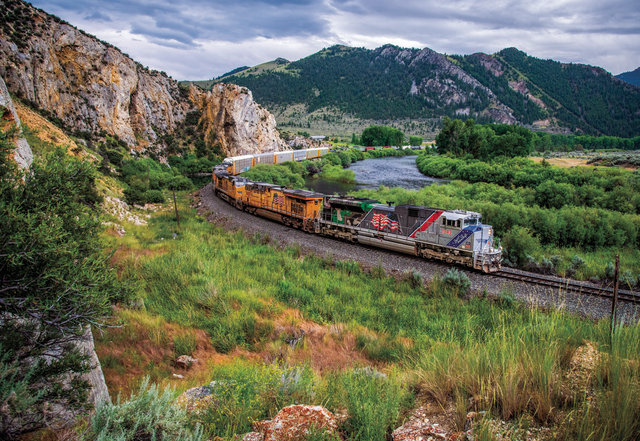 UP 1943 leads a manifest train along the Big Hole River at Maiden Rock, Montana.
