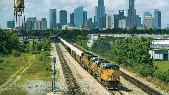 UP train moving away from Houston, Texas, skyline. | L
