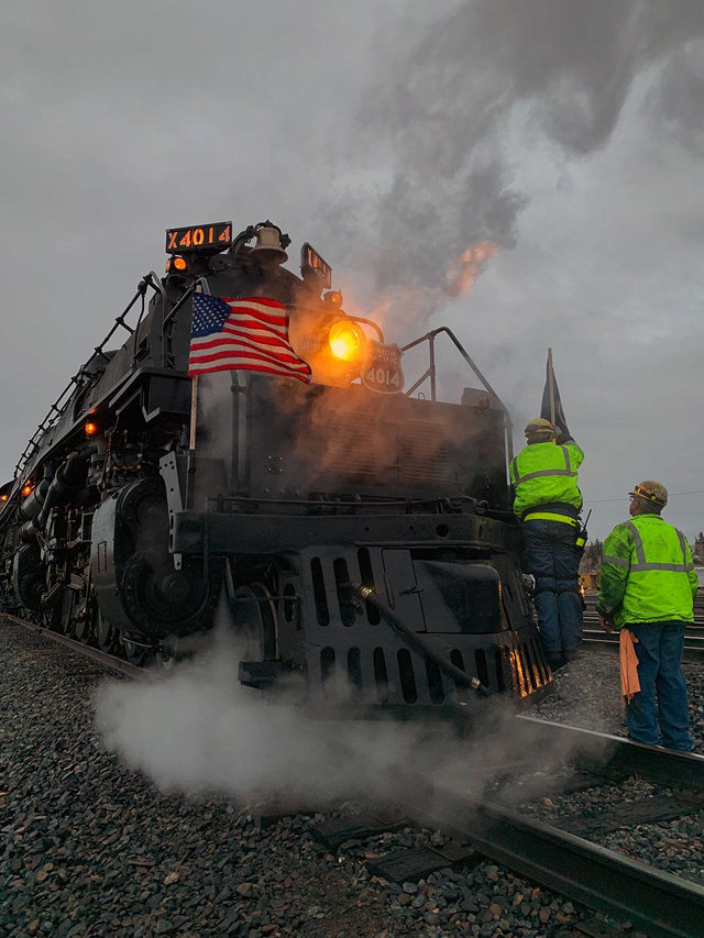 Union Pacific Big Boy No. 4014 steam locomotive operating at night, illuminated by headlights and surrounding lights.