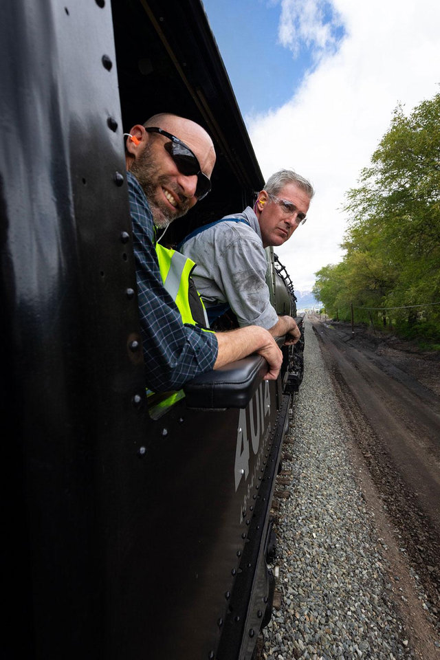 Union Pacific train crew members smiling and looking out of the cab window of Big Boy No. 4014.