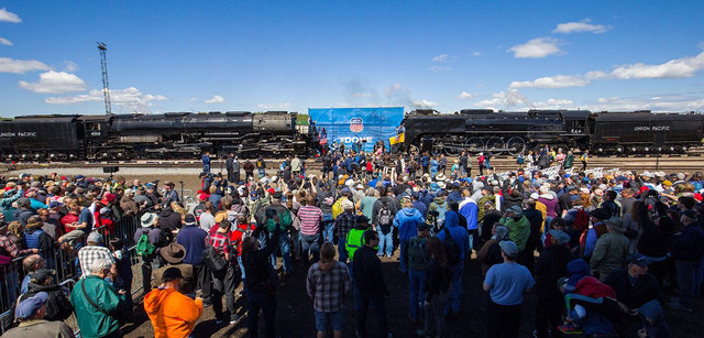 Large crowd gathered near railroad tracks as Union Pacific steam locomotives Big Boy No. 4014 and No. 844 stand side by side during a public event.
