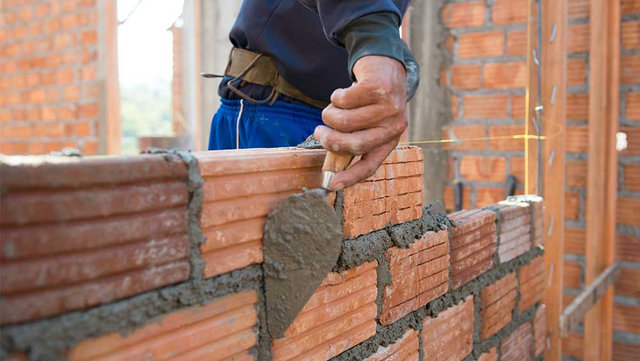 468996060 A worker building a brick wall