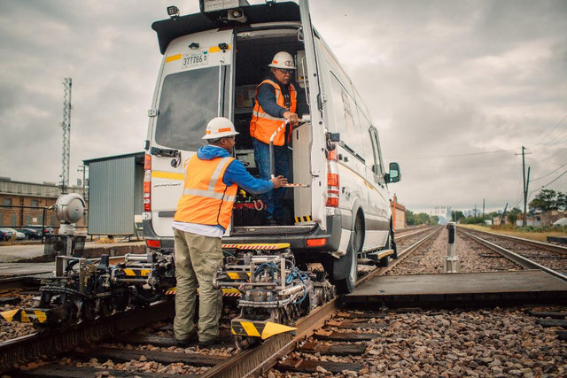 Track Inspectors Derrick Beard and Greg Wilson operate an ultrasonic rail inspection vehicle outside Chicago, Illinois, identifying rail defects with high frequency sound, which indicates the rail part needing maintenance.