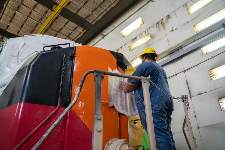 Carman Shaun Bateman applies the UP shield to the front of UP No. 1979 at Jenks Locomotive Shop in North Little Rock, Arkansas.