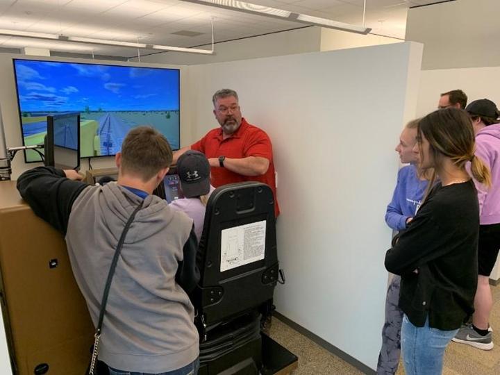 Senior Instructor Pat Morgan explains a locomotive training simulator scenario to local high school students.