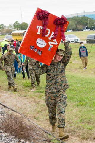 A U.S. Marine carries a box of donated toys off of No. 1943, The Spirit.