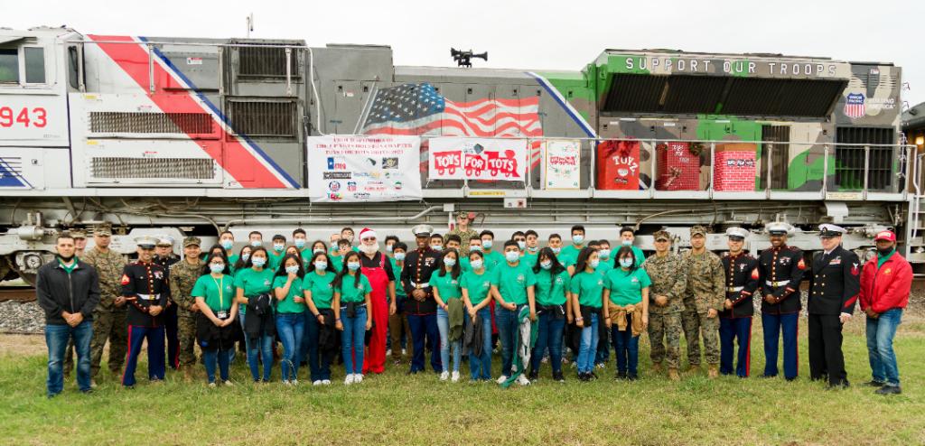 U.S. Marines, a local group of school children, railroaders and fellow members of the community stand before UP's Spirit Locomotive.