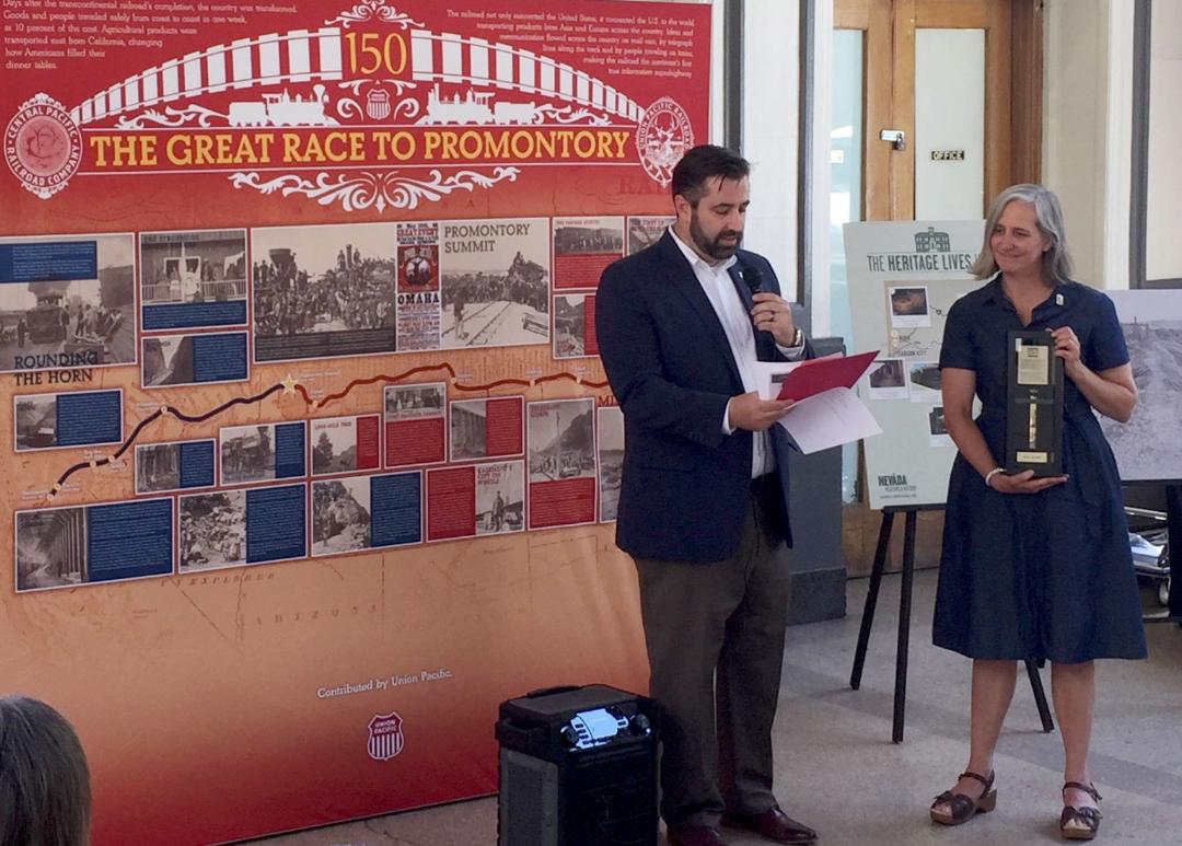 Union Pacifc's Senior Director of Public Affairs Nathan Anderson presents a commemorative Golden Spike to Reno, Nevada, City Council member Jenny Brekhus.