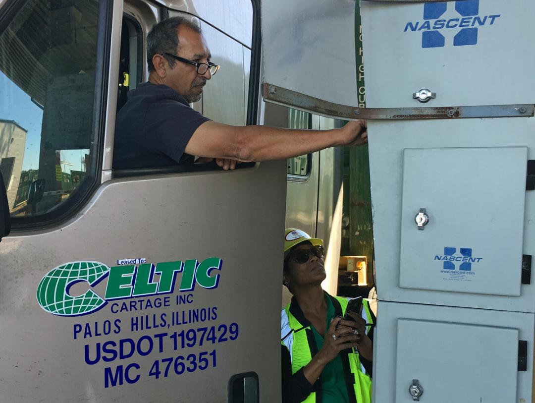 Elle Spencer, senior manager-Intermodal Operations, Premium Operations, helps a driver with UPGo in Oakland, California.