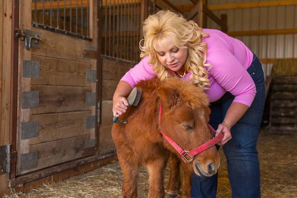 Suzan Caylen brushes a miniature horse.