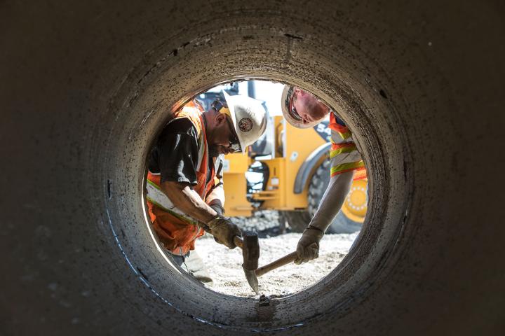 Medium | Inside Track: Salt Lake Causeway - workers framed by tube opening