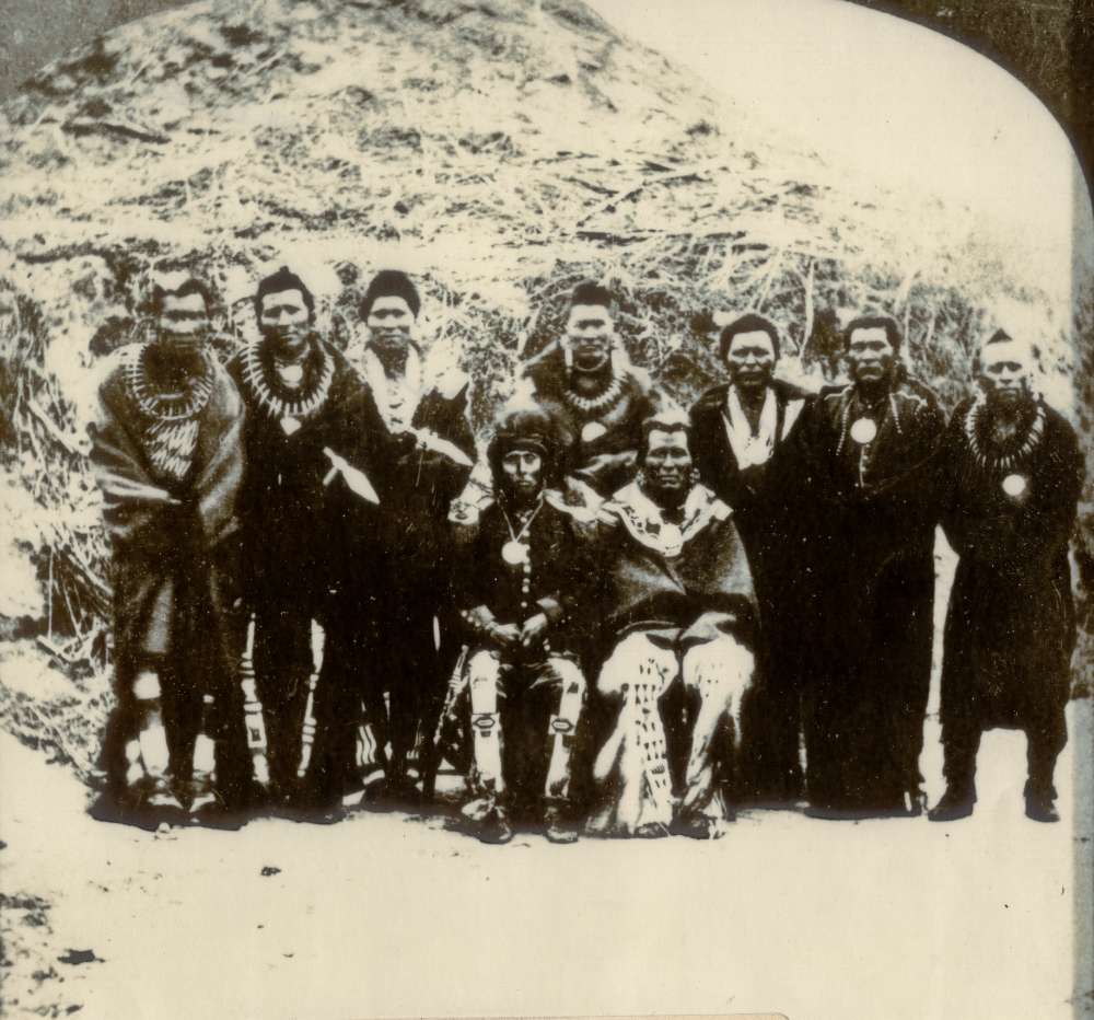 Members of the Pawnee Tribe pose for a photograph in front of a traditional earth lodge